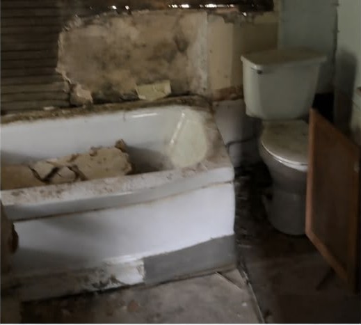 Before: New bath — tile surround, tub, toilet, vanity and plumbing.