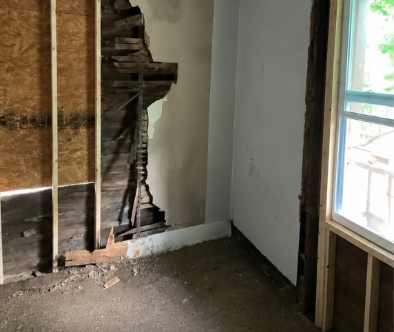 Before: Bedroom — rebuilt walls, new window, floors and ceiling fan.